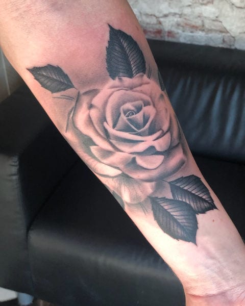 Juuls Tattoos gekeurde roos met blaadjes op onderarm