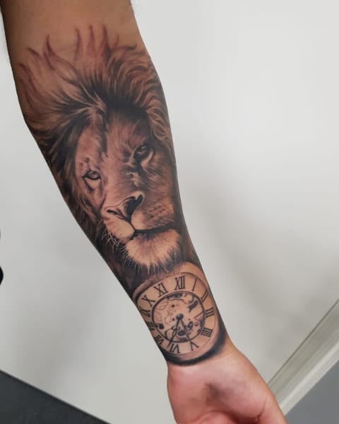 Tatt2Q leeuwenkop met klok tattoo op onderarm