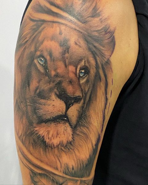 Leeuwenkop tattoo bovenarm Blxck bij Qualitatts tattooshop